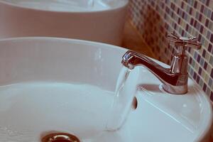 rubinetto dell'acqua con acqua corrente foto