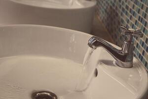 rubinetto dell'acqua con acqua corrente foto