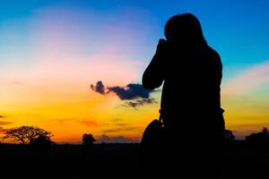 silhouette fotografo con tramonto foto