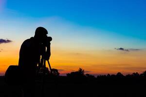 silhouette fotografo con tramonto foto
