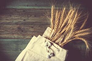 Grano orecchie su il di legno tavolo. covone di Grano al di sopra di legna sfondo. raccogliere concetto foto