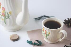 vicino su foto di un' tazza di dolce tè e un' bianca teiera con ceramica Materiale