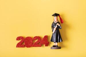 classe di 2024 concetto. numero 2024 con statuetta nel la laurea berretto e toga foto