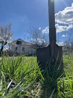 agricoltura. pala nel il terra primavera giardino villaggio. verticale foto