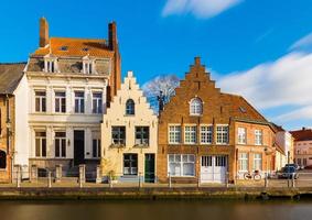 bruges, brugge, belgio - vista sulla strada delle vecchie case residenziali in stile architettonico tradizionale. facciate degli edifici storici e canale con acqua. foto