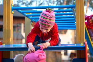 carino bambino giocando su il scala a il terreno di gioco foto