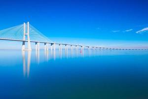 ponte vasco da gama specchiato sull'acqua, lisbona, portogallo foto