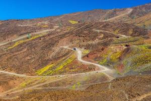 vista panoramica di una strada di montagna con un autobus che si sposta verso l'alto. colline di pietra vulcanica sull'Etna. sicilia, italia foto