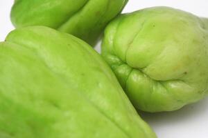 vicino su foto di tre fresco chayote su un' bianca sfondo