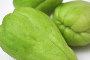 vicino su foto di tre fresco chayote su un' bianca sfondo