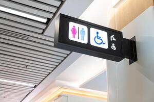 moderno pubblico gabinetto cartello su il parete. pubblico toilette segni con un' Disabilitato accesso simbolo. foto