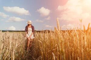 donna Grano campo. agronomo, donna contadino dai un'occhiata d'oro maturo orzo picchi nel coltivato campo. avvicinamento di femmina mano su piantagione nel agricolo Ritaglia gestione concetto. lento movimento foto