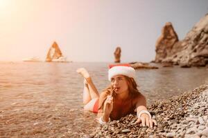 donna viaggio mare. contento turista godere assunzione immagine su il spiaggia per ricordi. donna viaggiatore nel Santa cappello sembra a telecamera su il mare baia, condivisione viaggio avventura viaggio foto