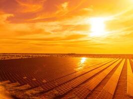 aereo superiore Visualizza di un' solare pannelli energia pianta. fotovoltaico solare pannelli a Alba e tramonto nel campagna a partire dal sopra. moderno tecnologia, clima cura, terra Salvataggio, rinnovabile energia concetto. foto