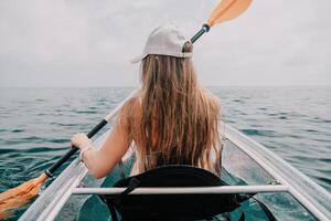 donna nel kayak indietro Visualizza. contento giovane donna con lungo capelli galleggiante nel trasparente kayak su il cristallo chiaro mare. estate vacanza vacanza e allegro femmina persone rilassante avendo divertimento su il barca foto