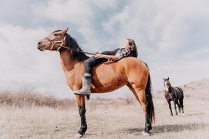 giovane contento donna nel cappello con sua cavallo nel sera tramonto luce. all'aperto fotografia con moda modello ragazza. stile di vita umore. concetto di all'aperto cavalcare, gli sport e ricreazione. foto