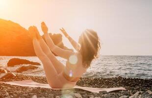 donna mare yoga. contento donna nel bianca costume da bagno e boho stile braccialetti praticante all'aperto su yoga stuoia di mare su tramonto. donne yoga fitness routine. salutare stile di vita, armonia e meditazione foto