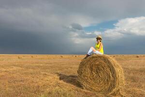 bellissimo giovane ragazza nel un' campo con cannuccia su un' sfondo di arcobaleno foto