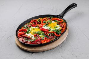 sostanzioso shakshuka tegame con fresco erbe aromatiche foto