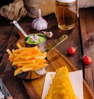 classico pesce e francese patatine fritte pasto con birra foto