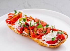 fresco pomodoro e formaggio Bruschetta su piatto foto