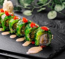 verde Drago Sushi rotolo su nero ardesia foto