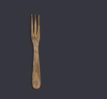 top up view in legno d'oliva cuoco servire forchetta isolato su sfondo scuro. adatto per il tuo elemento di design. foto