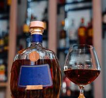 elegante Brandy bottiglia e bicchiere su bar contatore foto