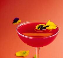 elegante cocktail con commestibile fiori su caldo sfondo foto