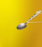 levitante cucchiaio su giallo sfondo foto