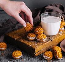 fresco al forno biscotti con latte su di legno tavola foto