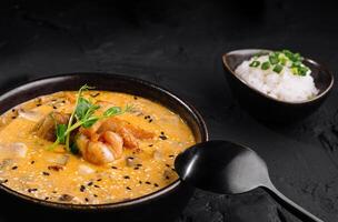 cremoso gamberetto curry con riso su buio tavolo foto