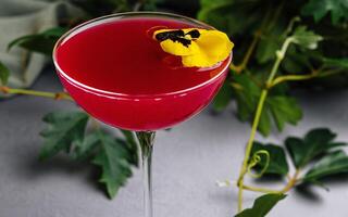 elegante cocktail con commestibile fiore contorno foto