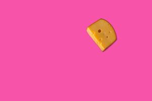 pezzo di formaggio in composizione concettuale creativa vista dall'alto piatta con copia spazio isolato su sfondo rosa in stile minimale foto