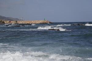 baia di Villaricos, ruvido mare, spiaggia, villaggio e montagne a il sfondo foto