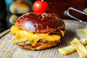 succoso hamburger al formaggio con fresco pomodoro fetta foto