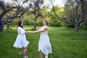 un' madre e sua adolescenziale figlia siamo abbracciare e giocando nel il giardino foto