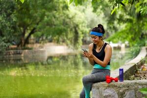 contento salutare indiano femmina scorrimento su mobile Telefono foto