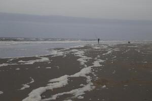 schiuma a il spiaggia, inverno nel il Olanda foto