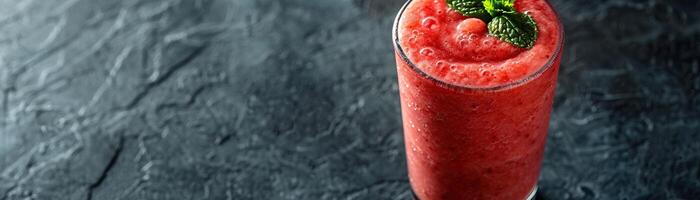 un' bicchiere di fresco fragola frullato su un' buio sfondo foto