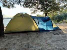 blu verde tenda di il lago, vacanza e campeggio concetto. nebbia al di sopra di il lago. mattina tempo foto