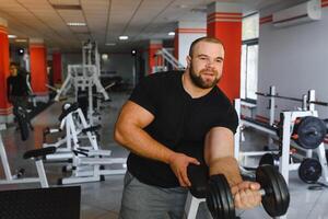 giovane bello uomo impegnato nel il Palestra foto