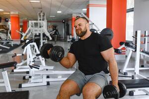 giovane bello uomo impegnato nel il palestra. foto