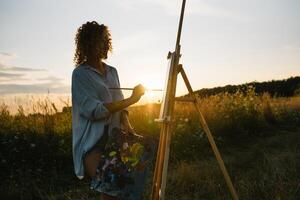 bella donna è la pittura. Aperto aria sessione. carino donna disegna un' immagine a tramonto. ragazza artista. foto