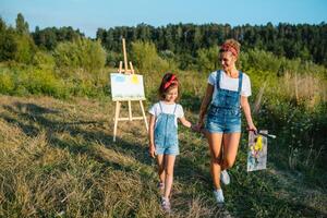 soleggiato natura, mamma e figlia dipingere un' immagine nel un' parco , pittura un' poco bambino, bambino creatività. La madre di giorno. foto