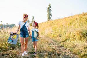 soleggiato natura, mamma e figlia dipingere un' immagine nel un' parco , pittura un' poco bambino, bambino creatività. La madre di giorno. foto