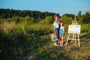 soleggiato natura, mamma e figlia dipingere un' immagine nel un' parco , pittura un' poco bambino, bambino creatività. La madre di giorno. foto