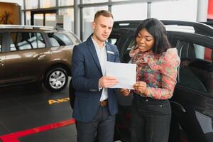 bellissimo giovane africano donna acquisto un' auto a concessionaria foto