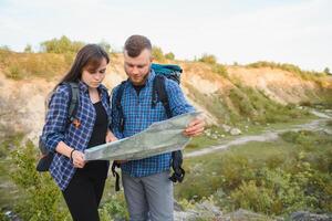 Due backpackers godendo scenario natura Visualizza mentre escursioni a piedi nel nazionale parco. coppia di escursionisti pianificazione Il prossimo modo per Esplorare Tenere carta geografica durante viaggio. infografica illustrazione carta geografica con superiore destinazioni foto