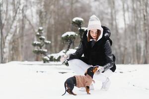 il ragazza passeggiate con un' cane nel il inverno. foto